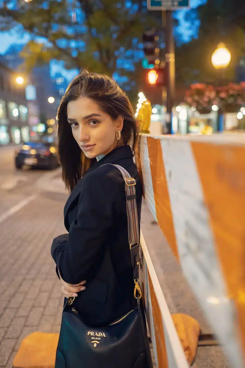 Pretty Woman in Black Blazer Carrying a Prada Bag while Looking at Camera